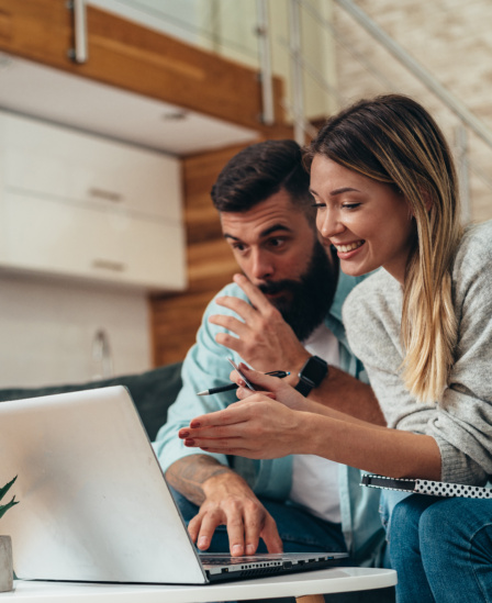 Couple Using A Laptop While Working On Their Home Finances